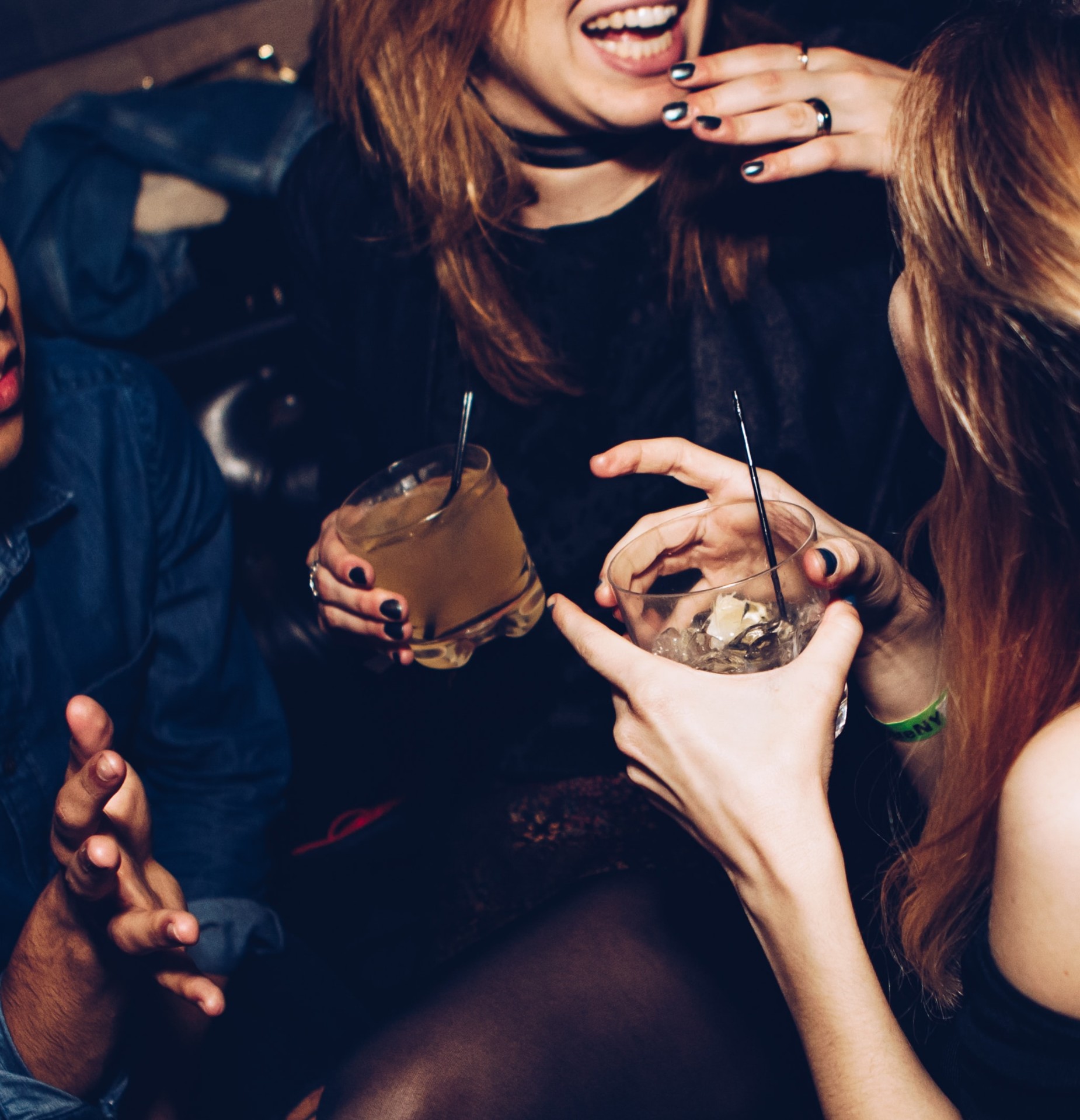 Friends laughing with cocktails in hand