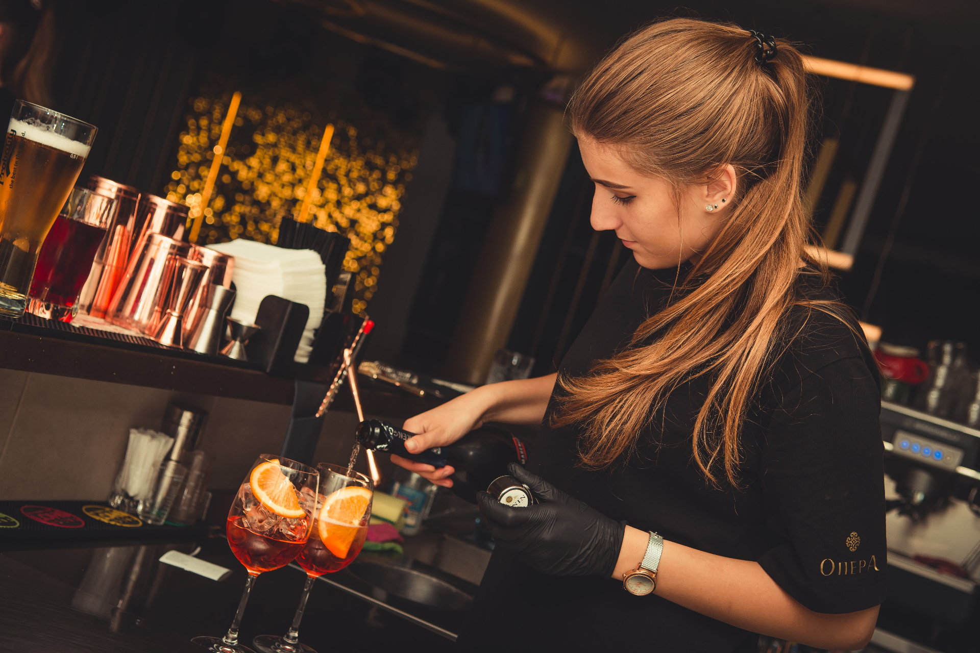Bartender topping up Aperol Spritz at the bar